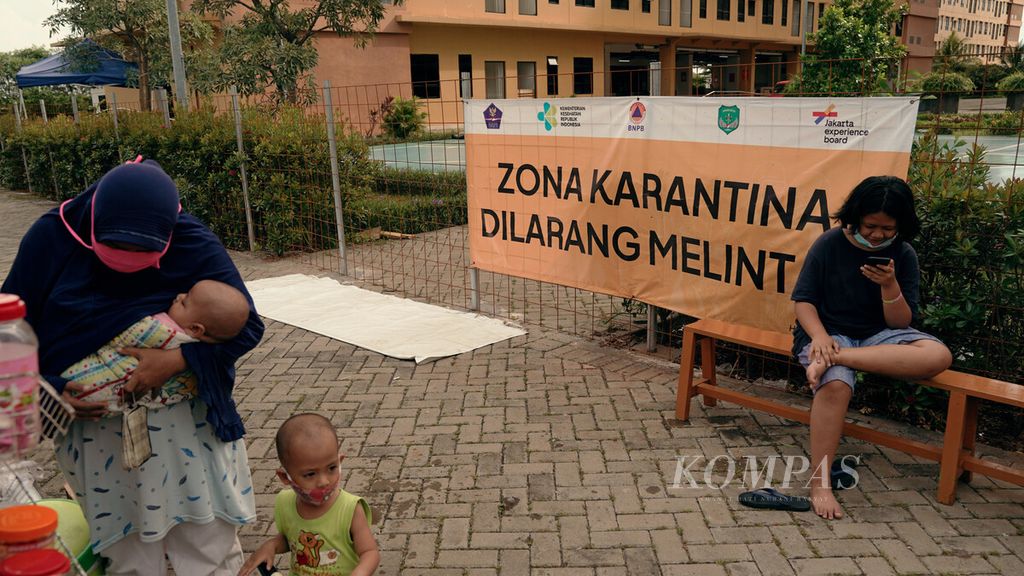 Warga berada di batas zona karantina di Rumah Susun Nagrak, Cilincing, Jakarta Utara, Minggu (9/1/2022). Kasus baru penularan Covid-19 varian Omicron terus bertambah.