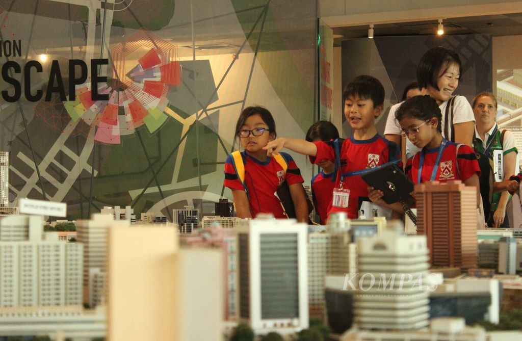 Sejumlah siswa memperhatikan maket yang menggambarkan tata kota Singapura di Singapore City Gallery, Selasa (10/10/2023). Sekolah-sekolah di negara itu memberdayakan galeri dan museum untuk menambah wawasan siswa.