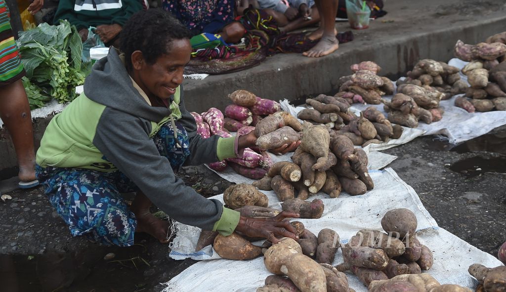 Penjual ubi di Pasar Tolikelek, Kabupaten Jayawijaya, Kamis (18/11/2022). Sejumlah warga kini masih menanam berbagai varietas ubi lokal yang selama ini ditanam masyarakat Papua. Ada ubi jenis helaleke, yeleli, dan musaneken. Total ada puluhan nama jenis ubi jalar di wilayah ini. Ubi merupakan makanan penting yang kini mulai tergantikan oleh nasi. 