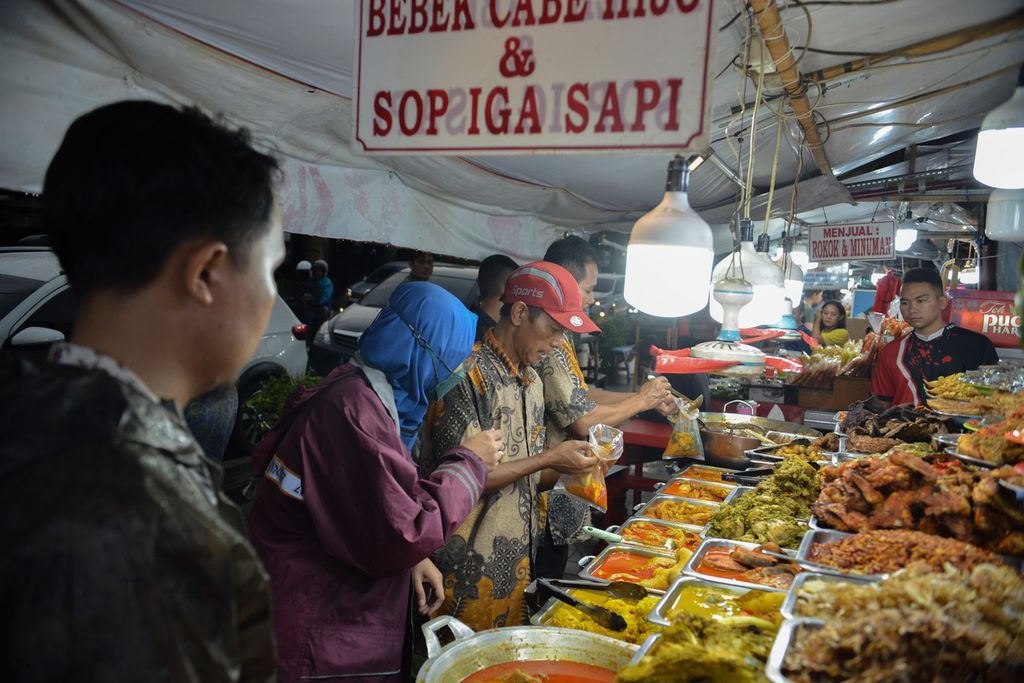 Para pedagang menyiapkan makanan yang dipesan warga di kawasan kuliner Jalan Kramat Raya, Jakarta Pusat, Jumat (14/4/2023). 