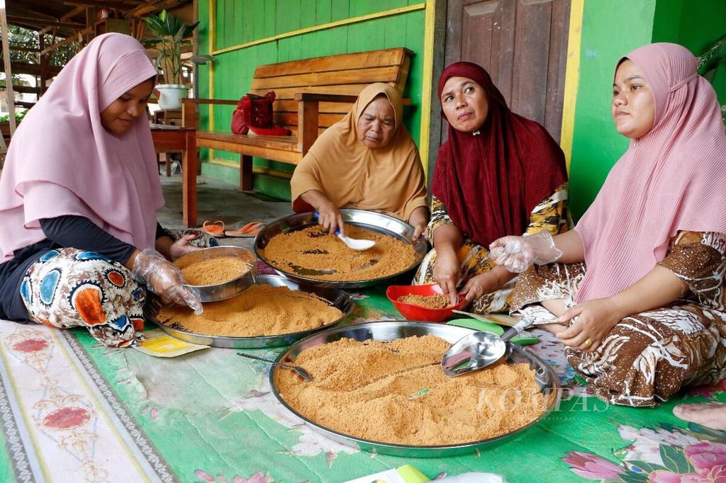 Anggota kelompok perempuan di Samar Kilang, Kecamatan Syiah Utama, Kabupaten Bener Meriah, Aceh, mengolah aren menjadi gula aren serbuk, 25 Januari 2022. Pemberdayaan perempuan di kawasan hutan Samar Kilang, selain untuk memajukan ekonomi, juga untuk mendorong warga memelihara hutan.