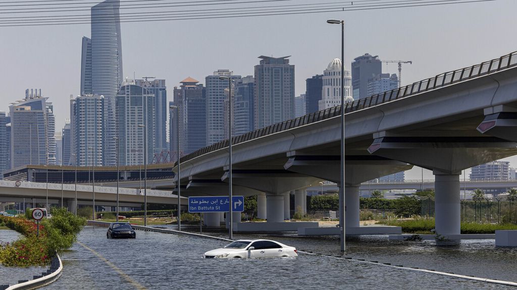 Mobil-mobil ditinggalkan warga karena terendam banjir di jalan bebas hambatan Sheikh Zayed di Dubai, Uni Emirat Aratb, Kamis (18/4/2024). 