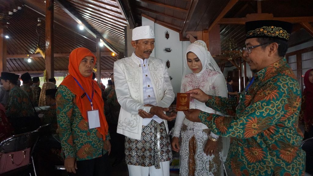 A bride and groom receive a marriage book in a series of mass wedding activities held in the framework of the 449th anniversary of Banyumas Regency, Central Java, Friday (28/2/2020).