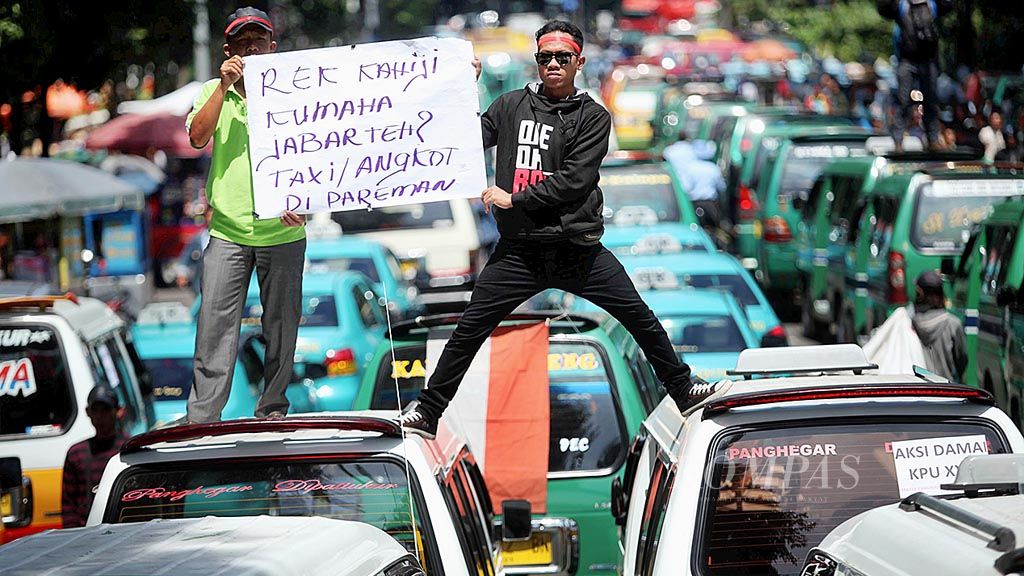 Sejumlah sopir angkutan kota di Kota Bandung menggelar aksi mogok beroperasi di depan Gedung Sate, Bandung, Jawa Barat, Kamis (9/3). Dalam aksi ini mereka menuntut pemerintah segera melarang pengoperasian angkutan berbasis daring yang dinilai merugikan mereka.