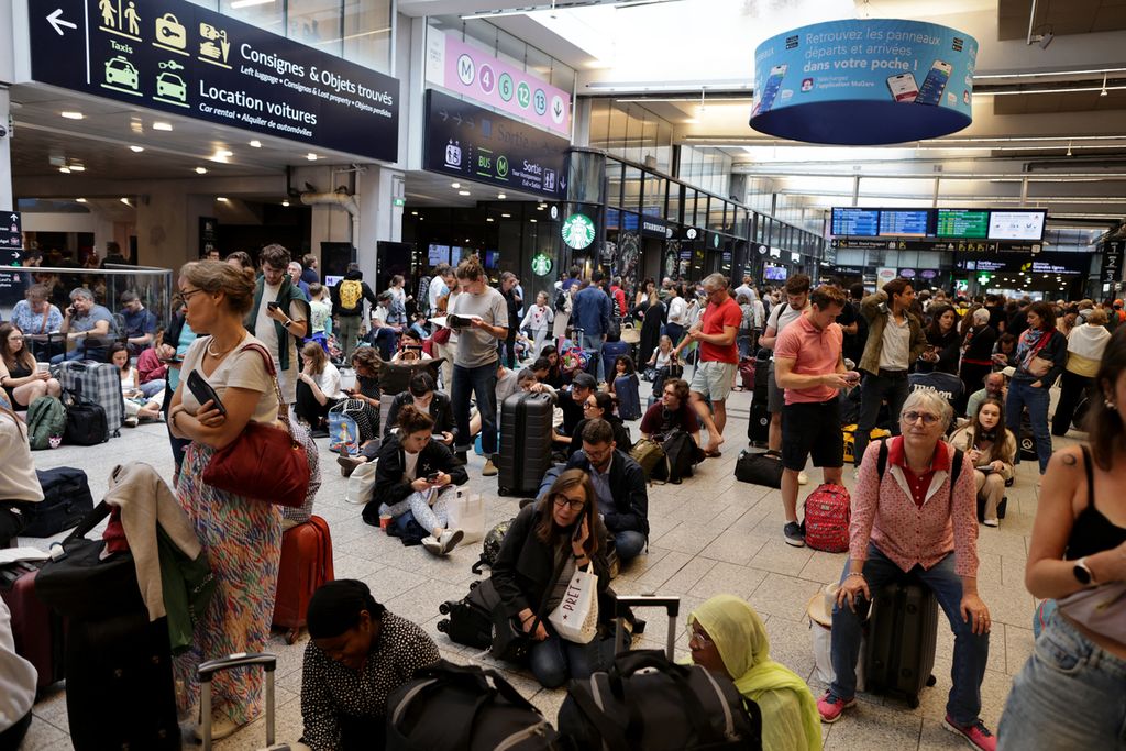 Para penumpang menunggu kedatangan kereta mereka di stasiun kereta Gare Montparnasse, Paris, Jumat (26/7/2024). 