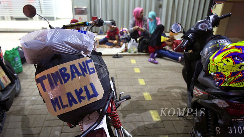 Pemudik sepeda motor beristirahat di Jalan Kalimalang, Bekasi, Jawa Barat, Jumat (23/6/2017). Pemudik menyertakan pesan-pesan unik yang ditempel di barang bawaan.