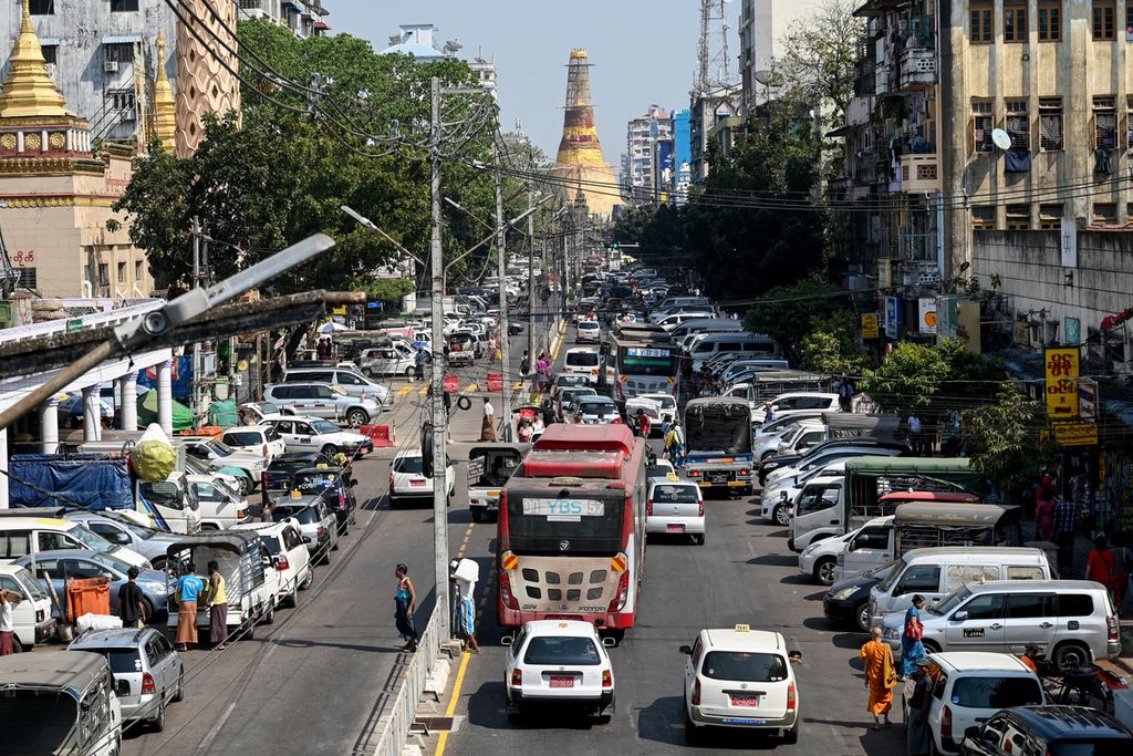 Pandangan umum menunjukkan lalu lintas di sepanjang Jalan Mahabandoola, dengan Pagoda Sule sebagai latar belakang, di Yangon pada 31 Januari 2023. Myanmar menandai dua tahun militer merebut kekuasaan sejak 1 Februari, menggulingkan pemerintah sipil dan menangkap pemimpin <i>de facto-</i>nya, Aung San Suu Kyi.