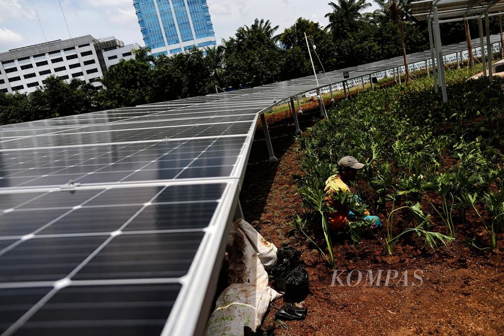 Pekerja merawat tanaman hias pada area panel surya di halaman Kompleks Parlemen, Jakarta, 13 Desember 2021. Indonesia memiliki potensi energi baru dan terbarukan (EBT) seperti tenaga angin dan surya. 
