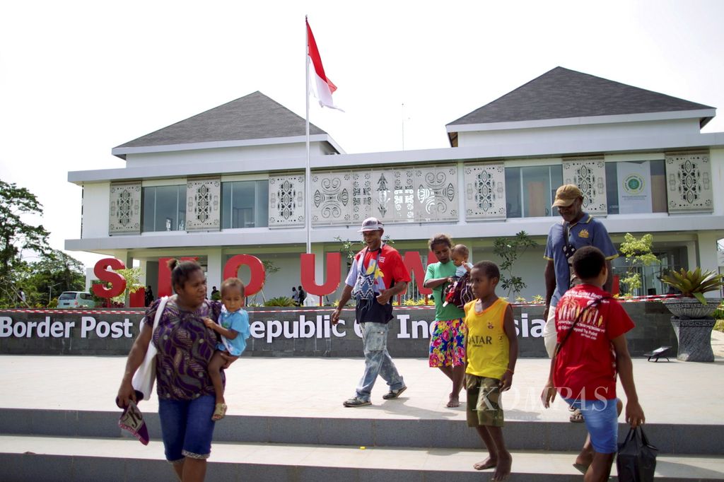 Warga Papua Niugini melewati Pos Lintas Batas Negara (PLBN) Skouw di Distrik Muara Tami, Jayapura, Papua, Sabtu (15/7). Kebanyakan warga berbelanja barang-barang kebutuhan sehari-hari di Pasar Skouw karena harganya lebih murah.
