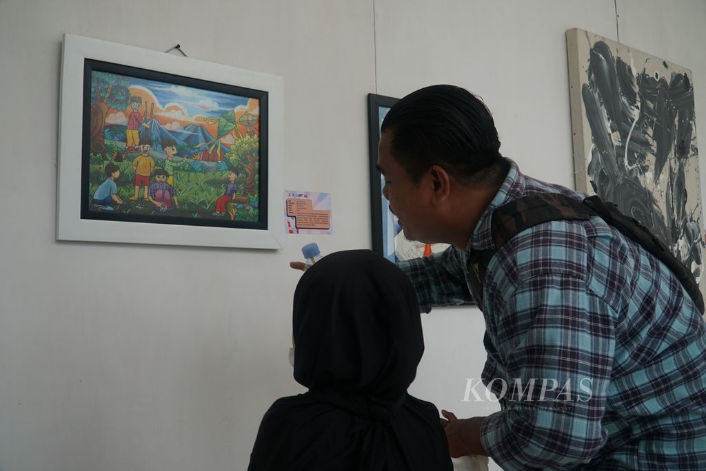Visitors accompanied their daughter to observe paintings created by children displayed at the West Sumatra Children's Festival 2023, held by the Women's Empowerment and Child Protection Agency, Population Control, and Family Planning of West Sumatra at the Governor's Palace of West Sumatra in Padang city, West Sumatra, on Saturday, November 18th, 2023.
