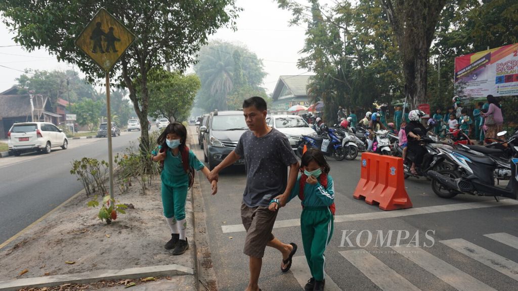 Orangtua menjemput anak-anaknya saat pulang sekolah di Kota Palangkaraya, Kalimantan Tengah, akhir Juli 2019. 