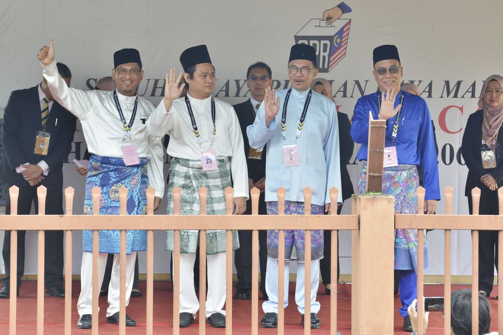 (Dari kiri ke kanan) Datuk Seri Ahmad Faizal Azumu (Perikatan Nasional), Abdul Rahim Tahir (Gerakan Tanah Air), tokoh oposisi Anwar Ibrahim (Pakatan Harapan), dan Md Hanafiah (Barisan Nasional) melambaikan tangan ke arah pendukung mereka setelah mendaftar dalam pemilu di Tambun, Malaysia, 5 November 2022. 
