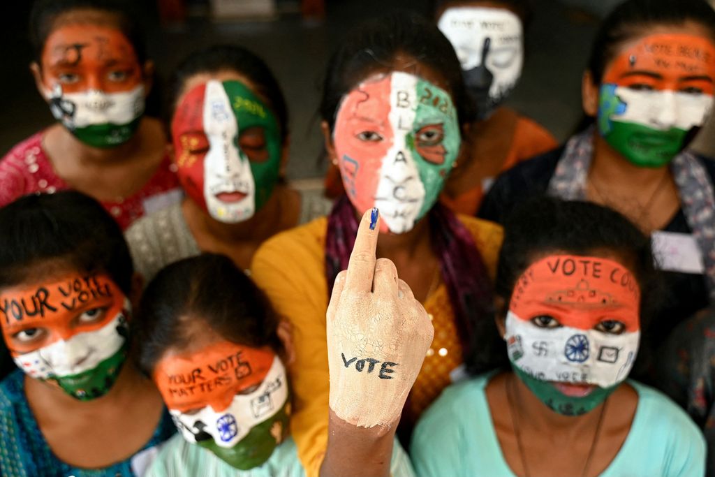 Mahasiswi di Chennai, India, 19 Maret 2024, mengecat wajah mereka dengan warna bendera India sebagai bagian dari sosialisasi pemilih menjelang pemilu negara itu yang akan dimulai pada 19 April 2024. 