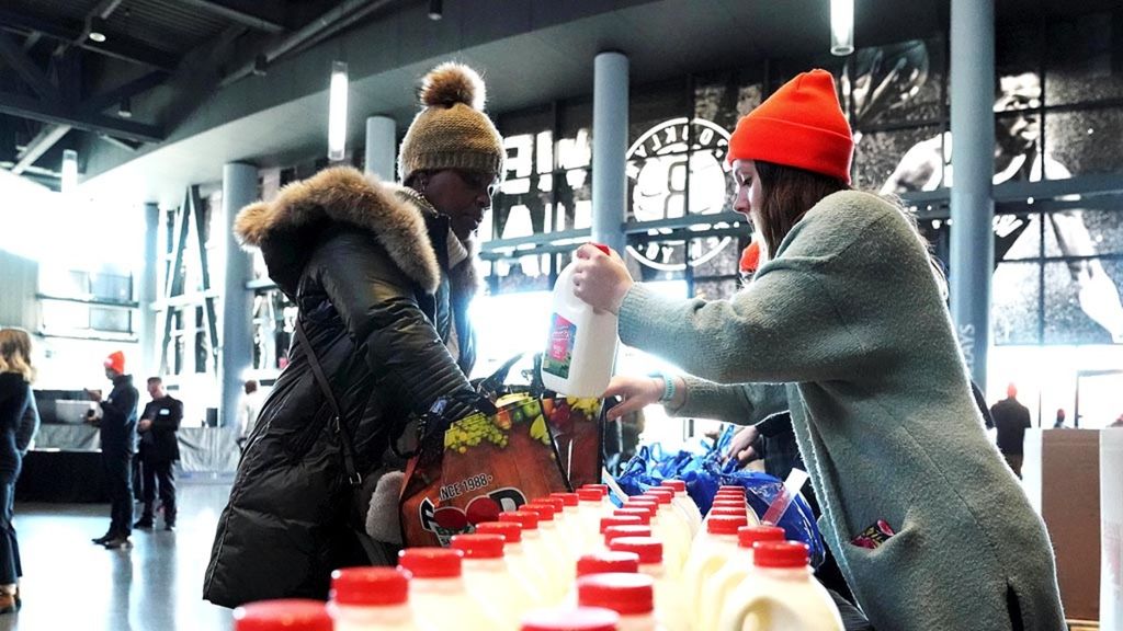 Pekerja federal, yang mengenakan mantel berkerah, memasukkan kantong makanan dan susu saat Food Bank For NYC mengadakan pembagian makanan untuk pekerja federal yang terdampak penutupan pemerintah di Brooklyn, New York, Amerika Serikat, 22 Januari 2019.