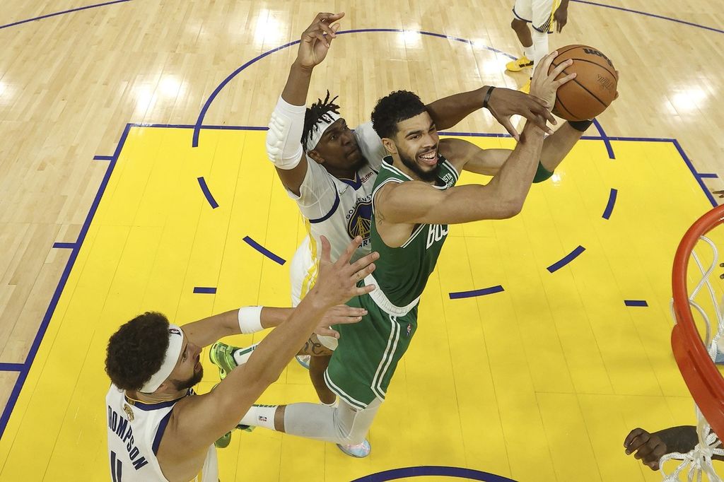 Pemain Boston Celtics, Jayson Tatum (kanan), melompat untuk memasukkan bola ke dalam keranjang Golden State Warriors dengan dihadang oleh pemain Warriors, Kevon Looney (kiri) dan Klay Thompson (bawah), pada laga kedua final NBA di Chase Center, San Francisco, Senin (6/6/2022) WIB. Warriors menang dengan skor 107-88 sehingga kedudukan menjadi 1-1. 