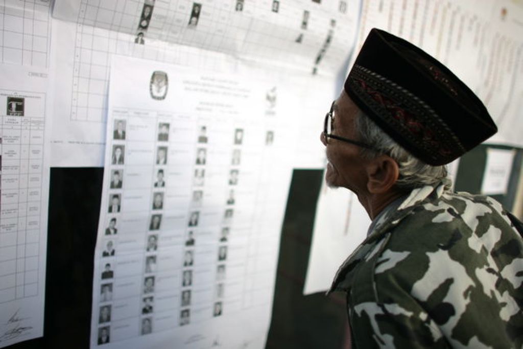 Husein, warga Kelurahan Bintaro, Jakarta, mengamati wajah-wajah baru calon anggota legislatif yang akan dia pilih menjelang pelaksanaan pemungutan suara di TPS 017 Kelurahan Bintaro, Kamis (9/4/2009).