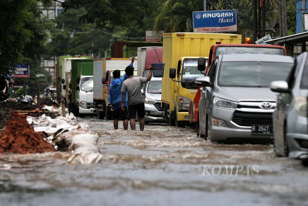 Warga memanfaatkan lalu lintas yang macet untuk meminta sumbangan kepada pengemudi di Jalan Husein Sastranegara, Benda, Kota Tangerang, Banten, Rabu (19/1/2022). 