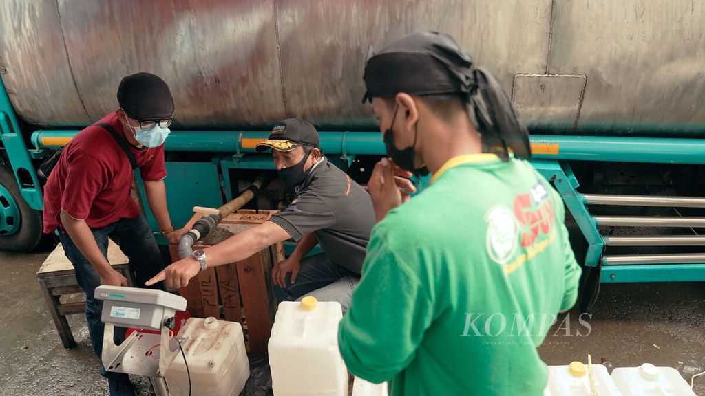 Petugas mengisi jerikan dalam distribusi mingguan minyak goreng curah di Pasar Perumnas Klender, Jakarta Timur, Jumat (25/2/2022). 