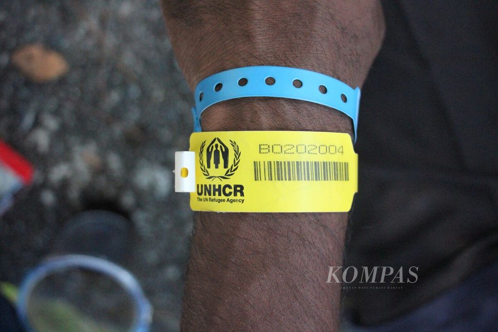 Gelang UNHCR tanda sebagai pengungsi dipakai oleh warga Rohingya saat berada di tempat penampungan sementara di Desa Ladong, Kecamatan Mesjid Raya, Kabupaten Aceh Besar, Aceh, Selasa (10/1/2023). Gelombang pengungsi Rohingya dari Bangladesh belum berhenti berdatangan ke Aceh.