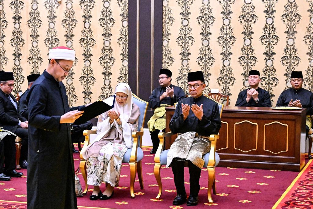  Perdana Menteri baru Malaysia Anwar Ibrahim (tengah, kanan), didampingi istrinya, Wan Azizah Wan Ismail (tengah, kiri), diambil sumpahnya dalam upacara pelantikan di Istana Nasional, Kuala Lumpur, Malaysia, Kamis (24/11/2022). 