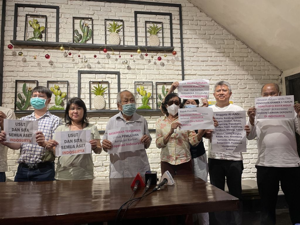 Para korban kasus gagal bayar Koperasi Simpan Pinjam Indosurya menunjukkan poster saat konferensi pers di Jakarta, Minggu (18/12/2022). Mereka menuntut majelis hakim memutuskan agar aset terdakwa yang disita dikembalikan ke mereka alih-alih diserahkan ke negara