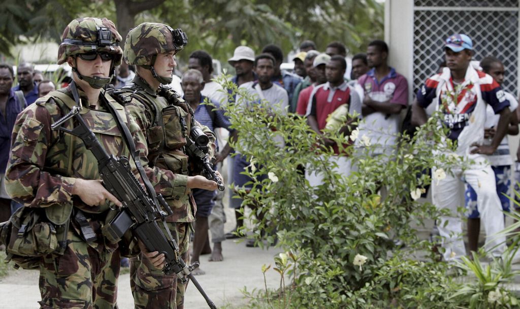 Tentara Selandia Baru berjaga di depan kerumunan yang terdiri dari ratusan warga Kepulauan Solomon di Honiara pada 25 April 2006. Keamanan di Solomon diperkuat oleh negara-negara di sekitarnya lewat perjanjian bilateral. 