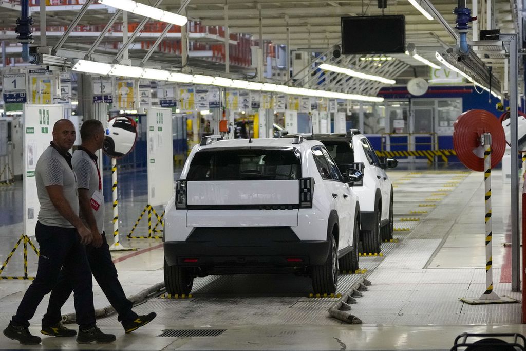 Para pekerja di pabrik otomotif Stellantis dengan latar mobil Fiat Grande Panda di Belgrade, Serbia, 22 Juli 2024.