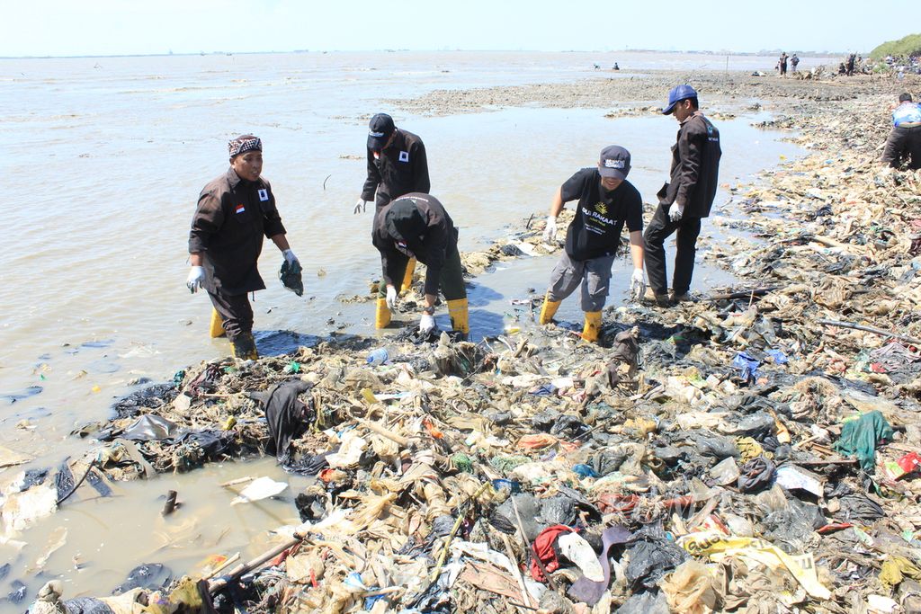Sukarelawan bersama petugas mengangkut sampah di Pantai Kesenden, Kota Cirebon, Jawa Barat, Sabtu (12/8/2023). 