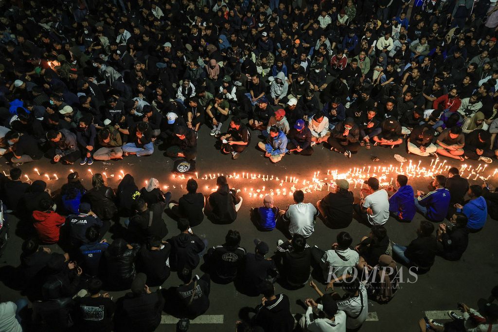 Thousands of Aremania pray together outside Gajayana Stadium, Malang, East Java, Sunday (2/10/2022). They lit candles and prayed for the victims of the Kanjuruhan tragedy which caused 134 people to die.