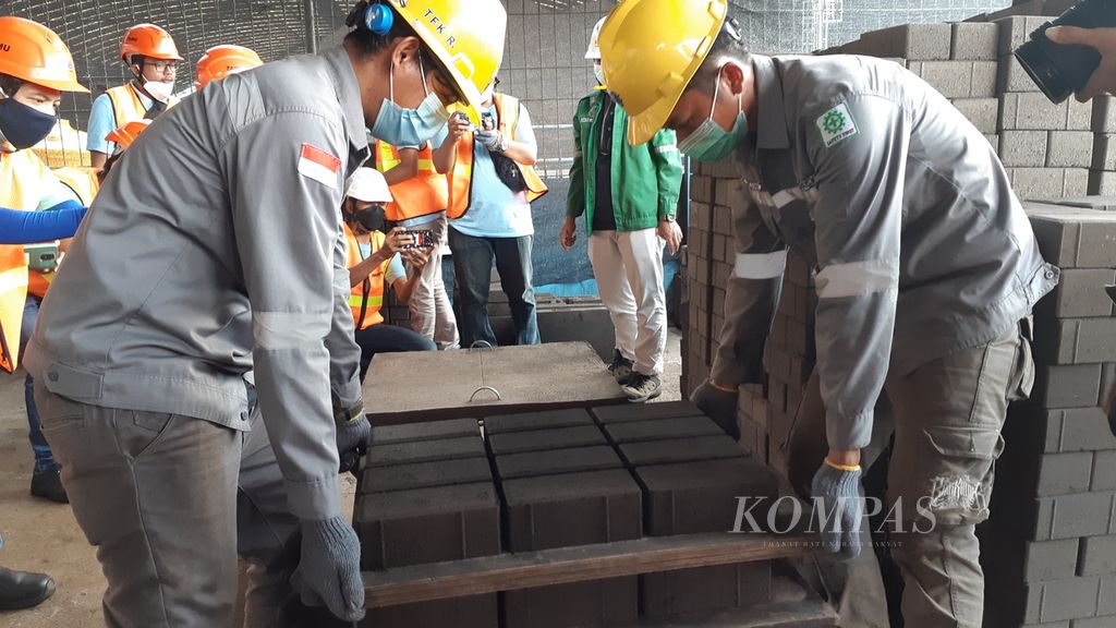 Pekerja mencetak balok paving dengan bahan baku limbah hasil pembakaran batubara di Workshop Pemanfaatan Fly Ash Dan Bottom Ash Unit Pembangkitan Jawa Bali Paiton Baru, Jawa Timur, Jumat (4/2/2022).