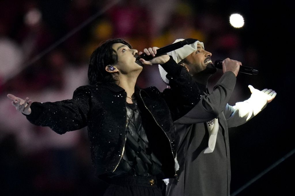 Penyanyi Korea Selatan yang merupakan personel BTS, Jung Kook (kiri), dan penyanyi Qatar Fahad Al Kubaisi tampil pada upacara pembukaan Piala Dunia 2022 di Stadion Al Bayt di Al Khor, Qatar (20/11/2022). Sebelum tampil di acara pembukaan, Jungkook terlebih dahulu merilis lagu resmi Piala Dunia 2022 bertajuk "Dreamers".