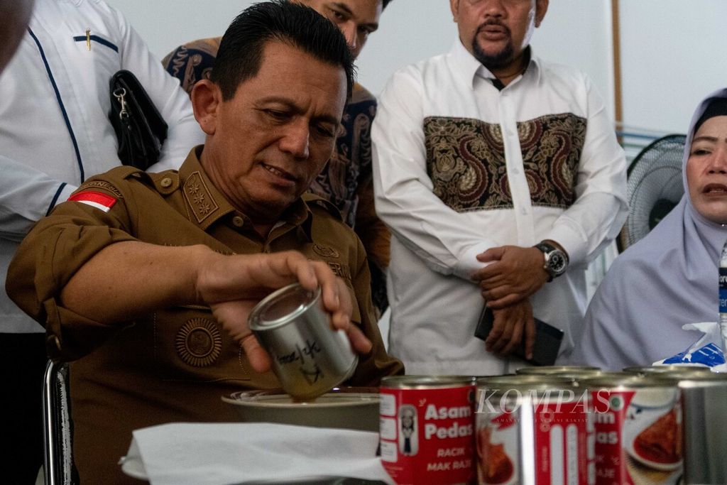 Gubernur Kepulauan Riau Ansar Ahmad mencoba salah satu makanan kaleng produksi UMKM Rumah Bungkus Radja Isha, di Batam, Kepulauan Riau, Senin (27/2/2023).