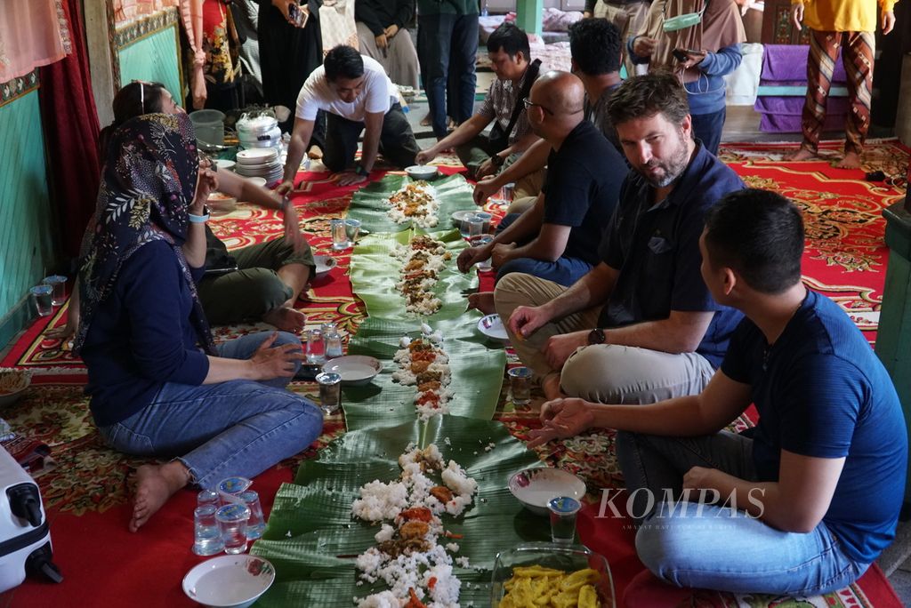 Rombongan Kedutaan Besar Amerika Serikat dan tim Pusaka Rasa Nusantara makan bajamba usai menyaksikan dan mendokumentasikan proses memasak rendang belut dan pangek pisang di Nagari Kinari, Kecamatan Bukit Sundi, Kabupaten Solok, Sumatera Barat, Kamis (26/5/2022).