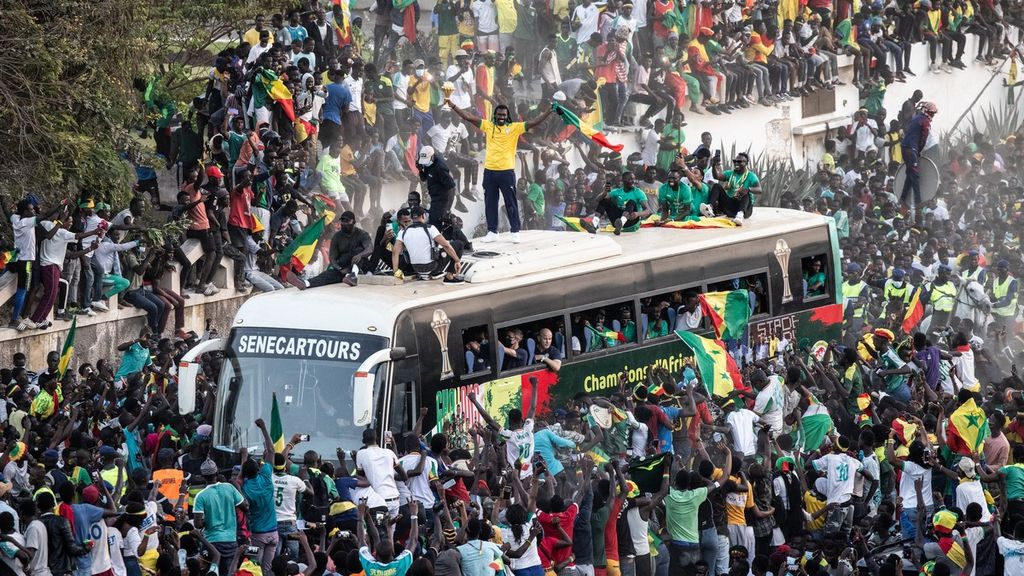 Pendukung menyambut kedatangan tim sepak bola Senegal yang untuk pertama kalinya memenangi Piala Afrika di pusat Kota Dakar, Senegal (7/2/2022).