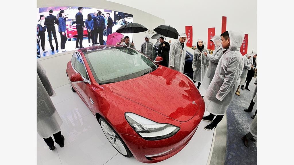 Para tamu melihat Tesla Model 3 selama upacara peletakan batu pertama pabrik Tesla di Shanghai, China, Senin (7/1/2019). CEO Tesla Elon Musk memimpin peletakan batu pertama itu. Pengembangan tersebut beriringan dengan negosiasi AS-China yang kala itu terpasung oleh perang dagang.