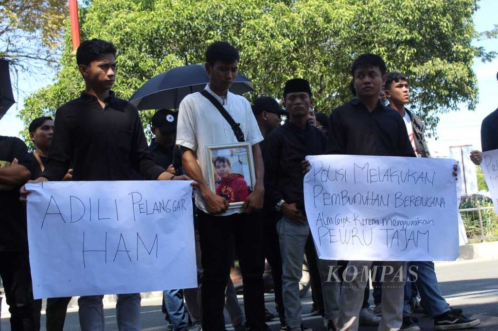 Keluarga Gijik (35), warga Desa Bangkal, Kabupaten Seruyan, Kalimantan Tengah, yang tewas ditembak aparat menuntut keadilan di depan Kejaksaan Tinggi Provinsi Kalteng, Kamis (14/3/2024).