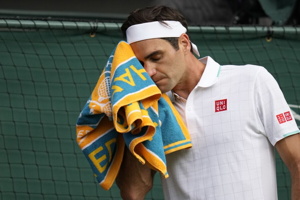 Petenis asal Swiss, Roger Federer, menyeka wajahnya dengan handuk saat menghadapi Hubert Hurkacz (Polandia) pada perempat final tunggal putra Wimbledon di London, Inggris, Rabu (7/7/2021). Federer mengumumkan akan pensiun. 