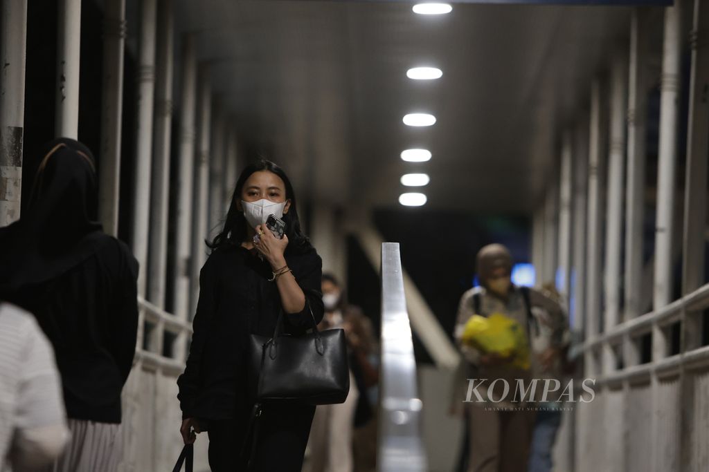 Warga mengenakan masker saat berjalan di atas jembatan penyeberangan orang di kawasan Dukuh Atas, Jakarta, Jumat (15/12/2023). Kementerian Kesehatan mencatat, hampir 300 orang terkonfirmasi positif Covid-19 pada 14 Desember 2023. 
