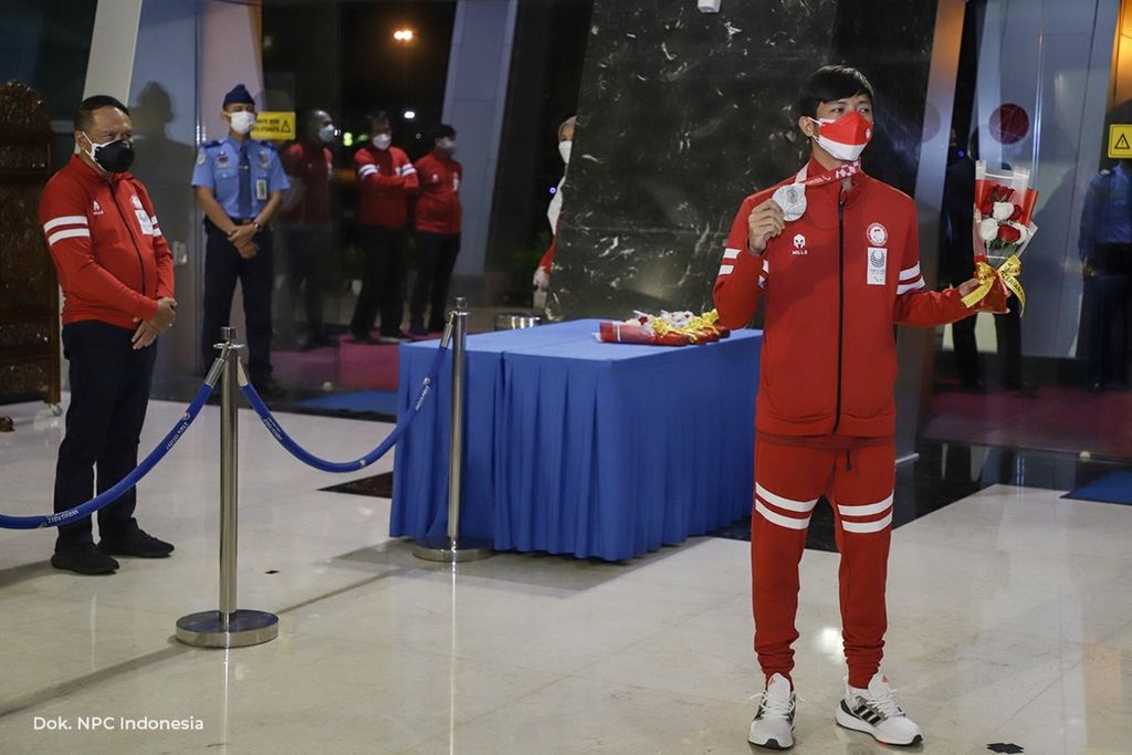 Pebulu tangkis tunggal putra SU5 Indonesia, Dheva Anrimusthi (kanan), disambut saat tiba di Terminal 3 Bandara Soekarno-Hatta Cengkareng, Tangerang, Selasa (7/9/2021). Ia meraih medali perak Paralimpiade Tokyo 2020. 