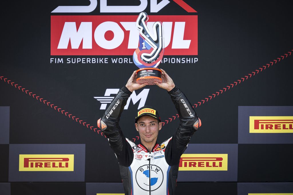 Pebalap tim Rokit BMW Motorrad WorldSBK, Toprak Razgatlioglu, mengangkat trofi seusai memenangi balapan 2 Superbike di Sirkuit Misano, Italia, Minggu (16/6/2024). Razgatlioglu memenangi balapan 1 Superbike seri Inggris di Donington Park, Sabtu (13/7/2024).