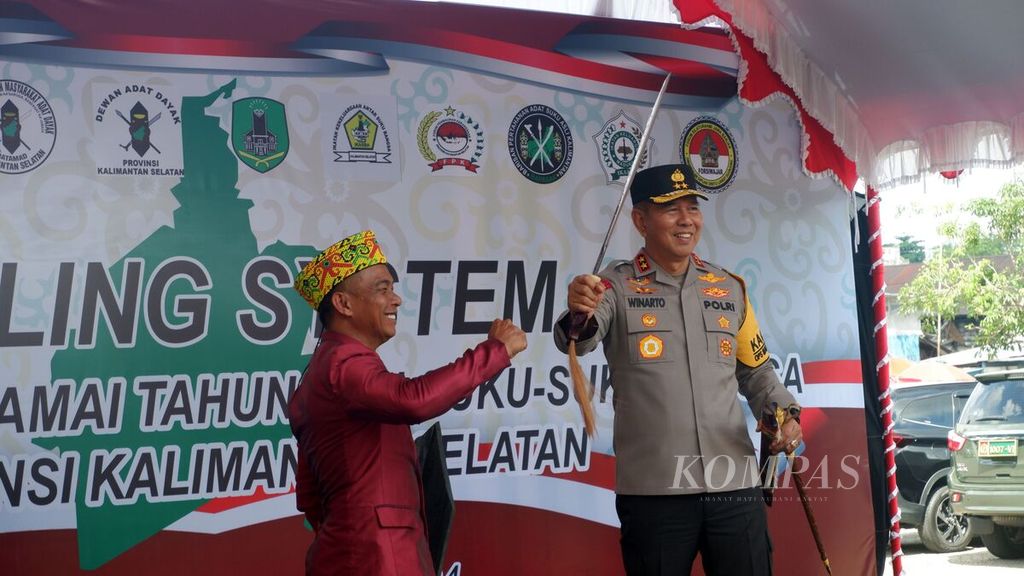 Kepala Kepolisian Daerah Kalimantan Selatan Inspektur Jenderal Winarto (kanan) menerima senjata mandau dari Ketua Umum Dayak Kulawarga Borneo Salam (kiri) dalam acara Cooling System Deklarasi Pemilu Damai Tahun 2024 Suku-suku Bangsa di Kalsel di Lapangan Kamboja, Kota Banjarmasin, Rabu (31/1/2024).