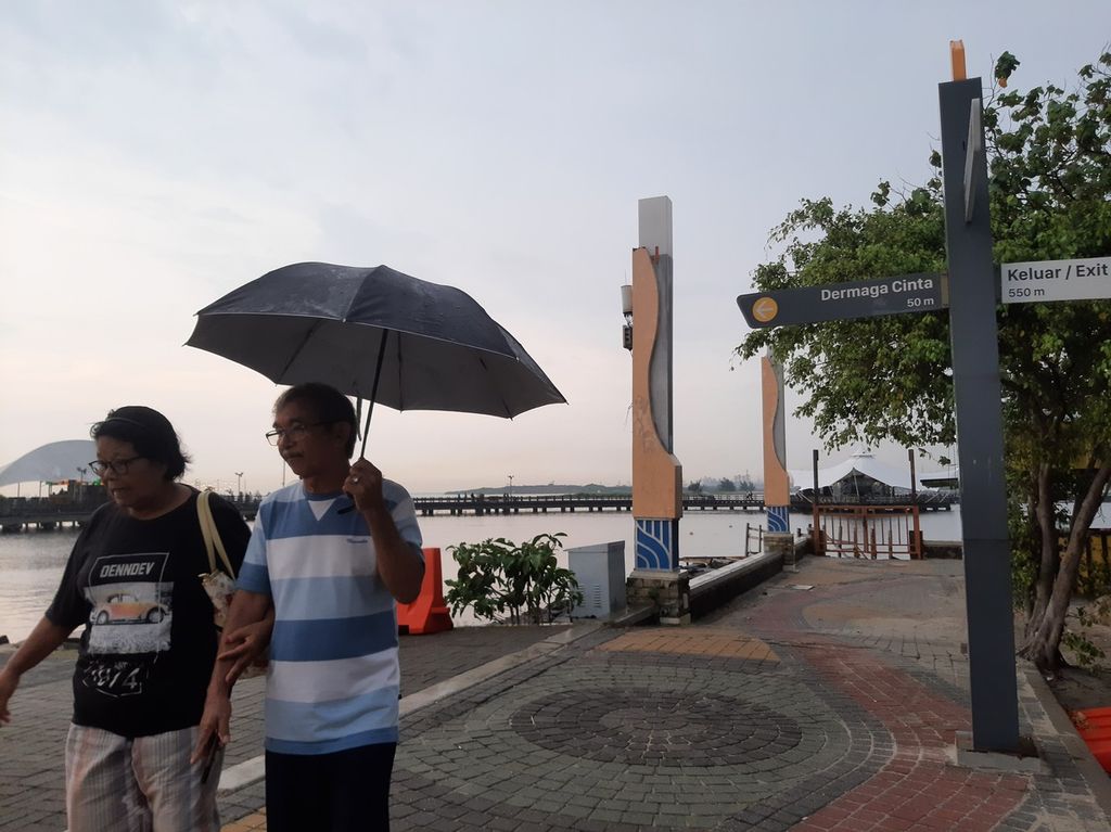 Hujan gerimis sore hari tidak menghentikan pengunjung dalam beraktivitas di kawasan Pantai Ancol, Jakarta, Sabtu (25/3/2023).