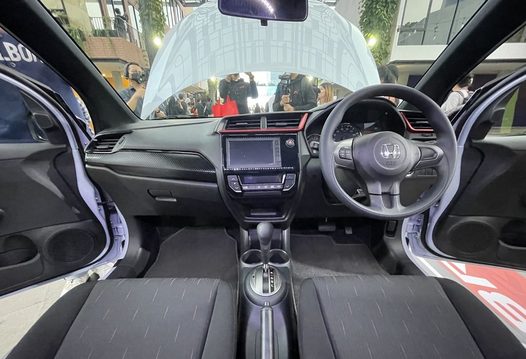 Bagian kabin Honda Brio RS edisi terbaru diimbuhi warna merah di bagian dasbor. Sarana hiburannya juga telah mendukung aplikasi Apple CarPlay dan Android Auto dengan sambungan kabel.