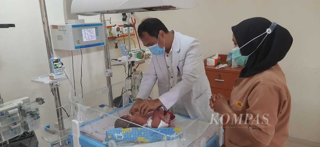 Sekretaris Tim Penanganan Bayi Kembar Siam RSUP H Adam Malik, Rizky Adriansyah, memeriksa bayi kembar siam dari Kabupaten Asahan, di Medan, Sumatera Utara, Rabu (8/6/2022). 