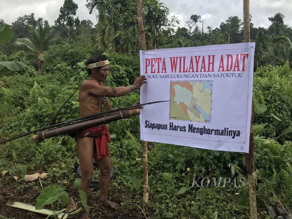 Seorang <i>sikerei</i> atau ahli spiritual Mentawai menunjukkan spanduk berisi peta wilayah adat mereka di Pulau Siberut, Kabupaten Kepulauan Mentawai, Sumatera Barat Senin (27/11/2017). Saat ini, mereka tengah dilanda kegelisahan karena wilayah adat mereka terancam oleh rencana masuknya hutan tanaman industri.