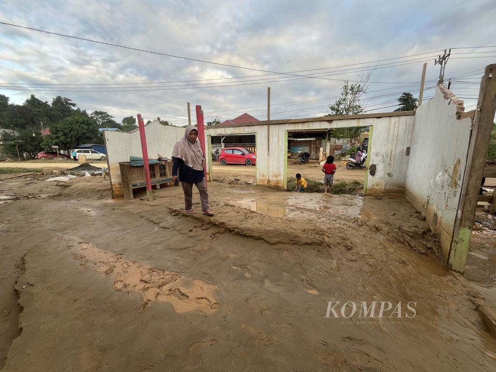 Siti Halia (56) berjalan lunglai di halaman rumahnya yang tertutup lumpur, di Kendari, Sulawesi Tenggara, Rabu (29/5/2024). Bencana banjir lumpur terus mengintai kota ini akibat penataan ruang yang tidak terkendali.