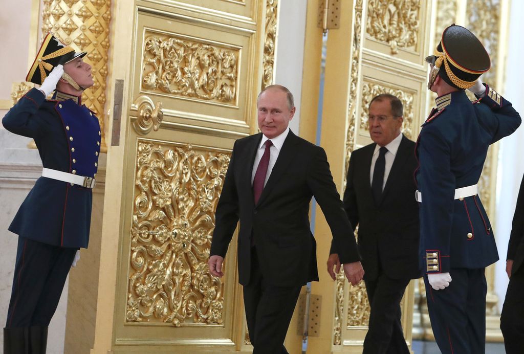 Presiden Rusia Vladimir Putin dan Menteri Luar Negeri Rusia Sergey Lavrov berjalan melewati pasukan kehormatan saat keduanya menghadiri upacara penyerahan surat kredensial dari para duta besar di Kremlin, Moskwa, Rusia, 11 Oktober 2018. 