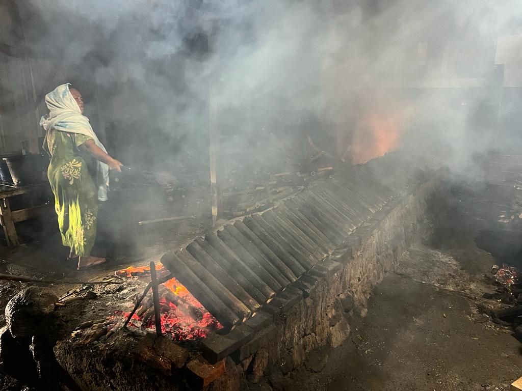 Daeng Kanang, pedagang lemang di Jeneponto, Sulawesi Selatan, memperbaiki letak lemang yang dibakar di warungnya, Sabtu (7/5/2022) malam.