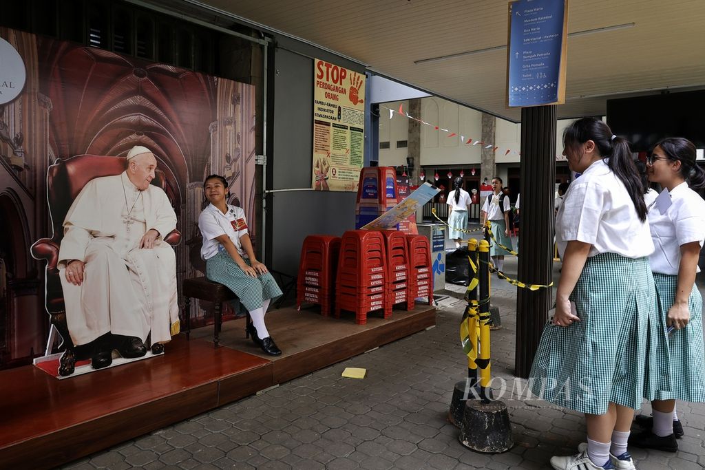 Pelajar berfoto bersama gambar Paus Fransiskus di Gereja Katedral Jakarta, Kamis (29/8/2024). Katedral Jakarta menyiapkan berbagai dekorasi khusus untuk menyambut kunjungan Paus Fransiskus ke Indonesia pada 3-6 September 2024. 