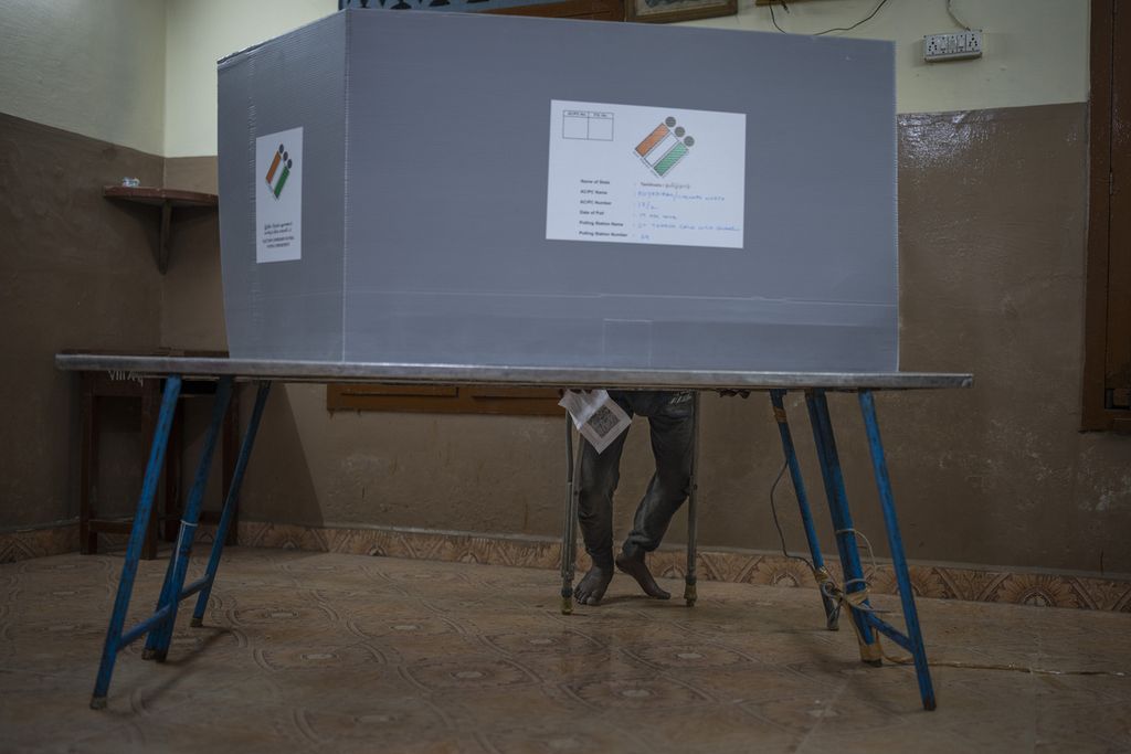 Seorang warga menggunakan hak suaranya di balik bilik suara di tempat pemungutan suara di Chennai, Tamil Nadu, India, Jumat (19/4/2024). India mulai melaksanakan fase pertama pemilihan umum yang diikuti sekitar 166 juta pemilih.  